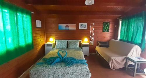 Un dormitorio con una cama con una cinta azul. en Cabañas Volcán Capellania, en Tinguatón