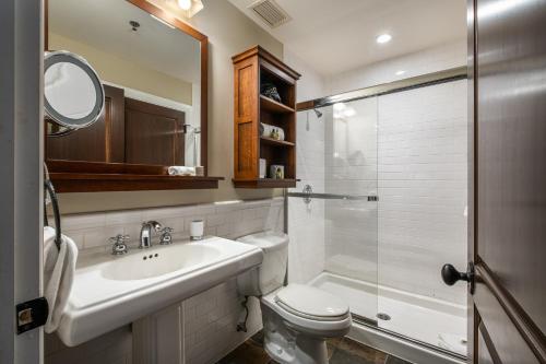 a bathroom with a sink and a toilet and a shower at Château Beauvallon in Mont-Tremblant