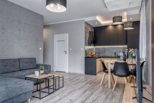 uma sala de estar com um sofá e uma mesa em Apartament K2 Pułaskiego 1 em Toruń