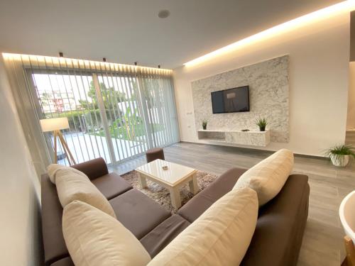 a living room with a couch and a tv at White Beach Villa 1 - Luxury in Velipojë