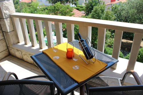 een tafel met glazen en een televisie op een balkon bij Apartments Marin in Bol