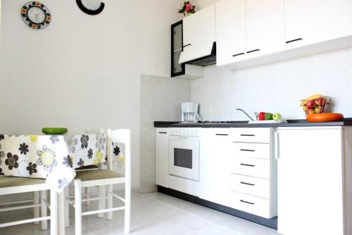 La cuisine est équipée de placards blancs et d'un four avec plaques de cuisson blanches. dans l'établissement Apartments Marin, à Bol