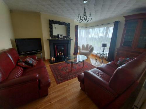 a living room with a couch and a table and a fireplace at HOMELY YELLOW BUNGALOW -Articlave-near Castlerock in Castlerock