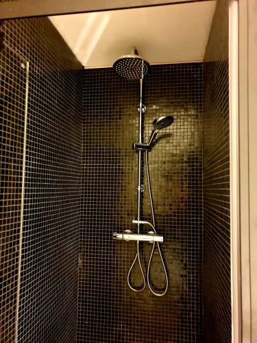 a shower with two tennis rackets on the wall at Studio Belga Begijnhof Tongeren in Tongeren