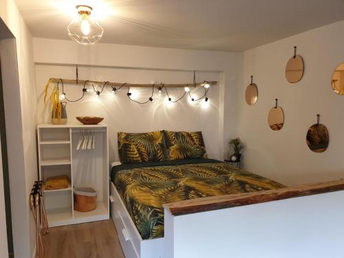 a bedroom with a bed and lights on the wall at Studio Belga Begijnhof Tongeren in Tongeren