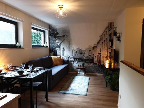 uma sala de estar com um sofá e uma mesa em Studio Het Begijntje Tongeren em Tongeren