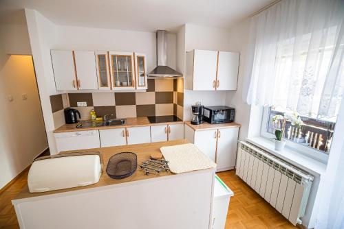 a kitchen with white cabinets and a wooden counter top at Vila K29 in Bovec