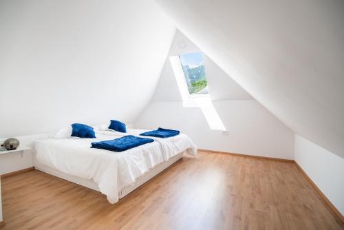 a white bedroom with a bed with blue pillows on it at Vila K29 in Bovec