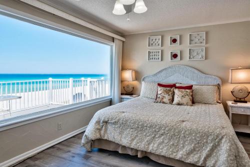 a bedroom with a bed and a large window at A View To Sea! West End! Sleeps 12! Hot Tub! in Panama City Beach