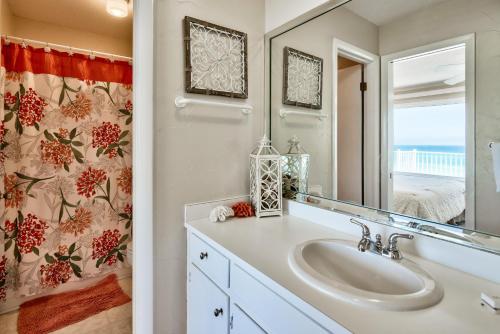 a bathroom with a sink and a mirror at A View To Sea! West End! Sleeps 12! Hot Tub! in Panama City Beach