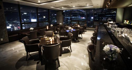 a restaurant with tables and chairs and a view of the city at Fraser Place Namdaemun Seoul in Seoul