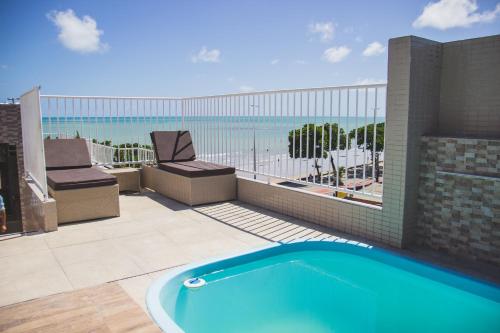 a swimming pool on a patio with a view of the ocean at Hotel Costa do Atlântico in João Pessoa