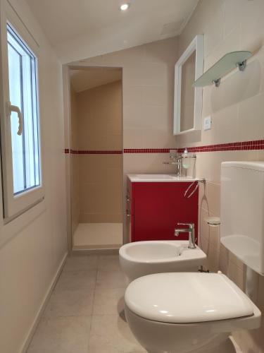 a bathroom with a white toilet and a sink at Borgo di Ponte Holiday Apartments & Rooms in Cividale del Friuli
