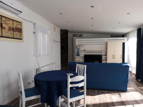une salle à manger avec une table bleue et des chaises dans l'établissement Apartman Dvorištance, à Golubac