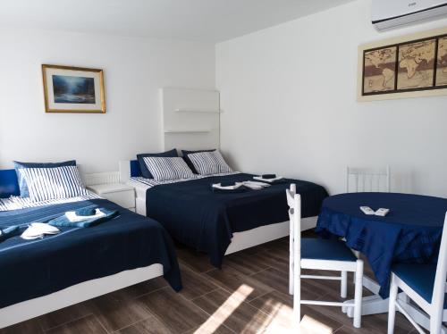 Cette chambre comprend deux lits, une table et des chaises. dans l'établissement Apartman Dvorištance, à Golubac