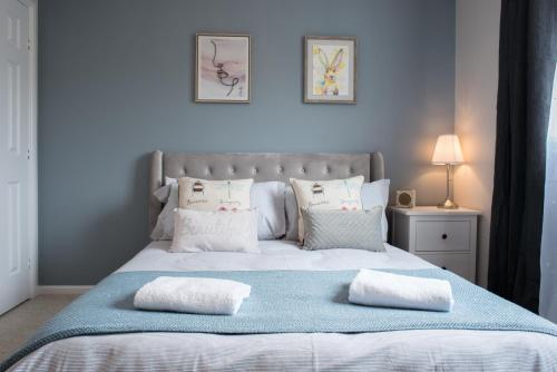 a bedroom with a large bed with two pillows on it at Green Lake House in Bourton on the Water