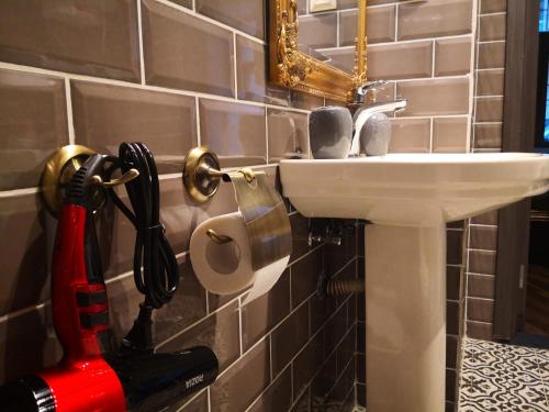 a bathroom with a sink with a chainsaw next to it at Затишні апартаменти, Дерибасівська in Odesa