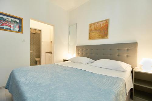 a bedroom with a large bed with a blue blanket at Apartment Rose Garden in Dubrovnik