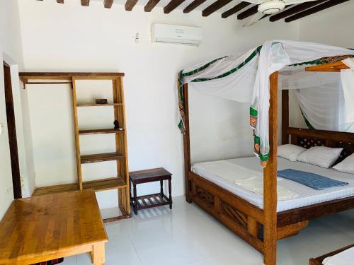 a room with a bunk bed and a wooden ladder at Zava Nungwi in Nungwi