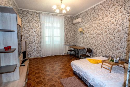 a bedroom with a bed and a table in it at Двухкомнатная квартира в самом ЦЕНТРЕ Николаева !СОБОРНАЯ! 3 РАЗД МЕСТА in Mykolaiv