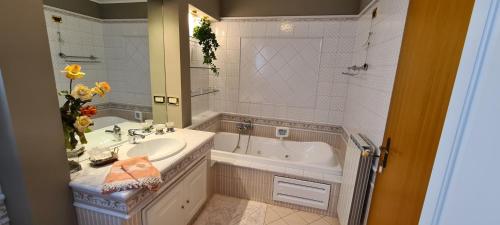 a bathroom with a tub and a sink and a bath tub at B&B Isonzo in Turriaco