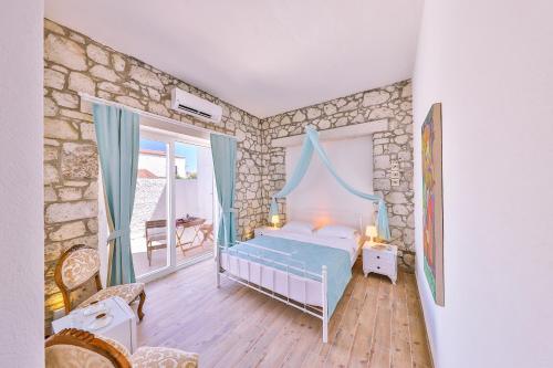a bedroom with a bed and a stone wall at Lale Lodge Hotel in Alacati