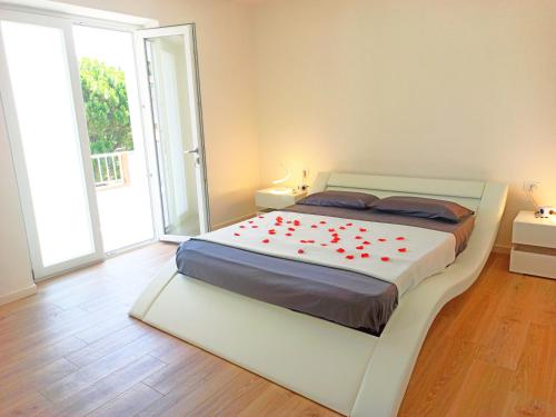 um quarto com uma cama grande com flores vermelhas em Guest House - La bella vita em Orosei