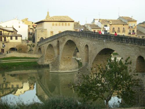 a stone bridge over a river in a city at Hotel El Cerco in Puente la Reina