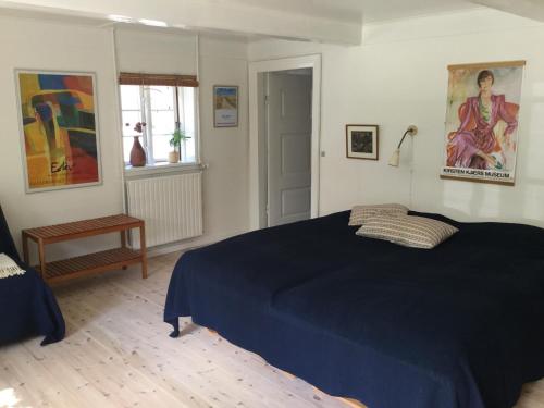 a bedroom with a blue bed and a window at Filippavej 80 in Vester-Skerninge