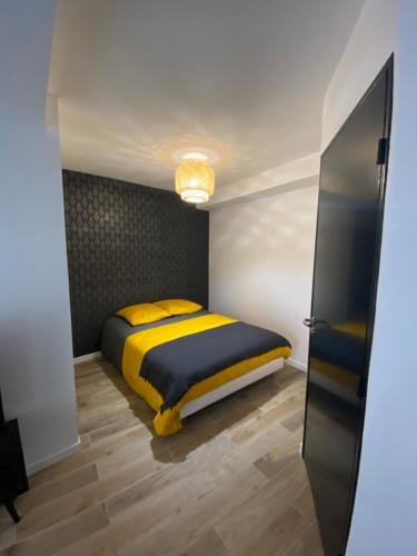 une chambre avec un lit avec des oreillers jaunes dans l'établissement Le PANCAUT, à Mont-de-Marsan