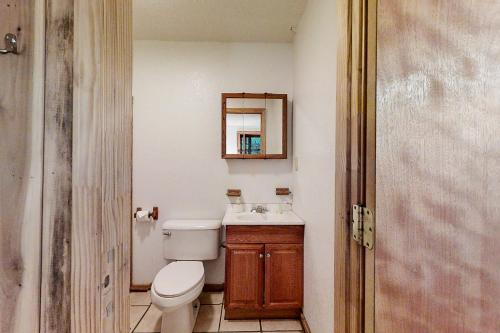 Un baño con inodoro, lavabo y espejo. en Horseshoe Bend, en Whittier