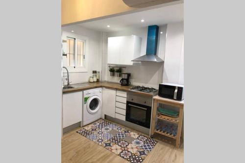 a kitchen with a stove and a washer and dryer at Appartement ALFONSO in Salou