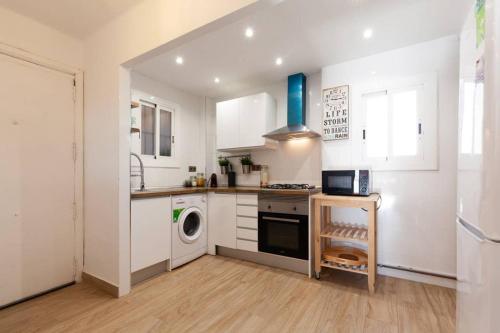 a kitchen with white cabinets and a washer and dryer at Appartement ALFONSO in Salou