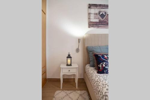 a bedroom with a bed and a nightstand with a lamp at Appartement ALFONSO in Salou