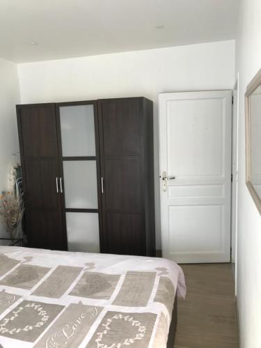 a bedroom with a large bed and a closet at Chambres d'hôte du Domaine de la Reine Blanche in Criquetot-sur-Longueville