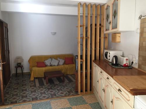 a kitchen with a couch in the corner of a room at Plein Sud : jolie maison dans village pittoresque de l'Hérault. in Nizas