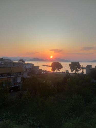 a sunset over a city with trees in the foreground at Panorama in Pefki