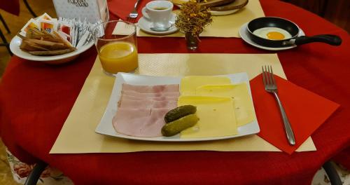 a plate of food with meat and pickles on a table at B&B Isonzo in Turriaco