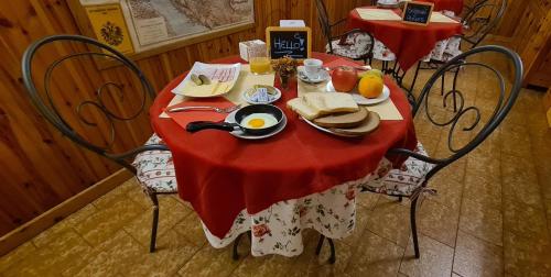 a table with a red table cloth with breakfast food on it at B&B Isonzo in Turriaco