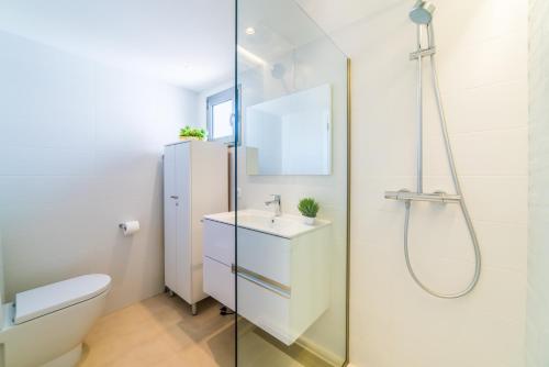 a bathroom with a toilet and a sink and a shower at Sa Maniga 6E in Cala Millor