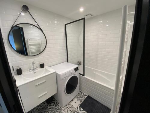 une salle de bain blanche avec un lavabo et un miroir dans l'établissement Le PANCAUT, à Mont-de-Marsan