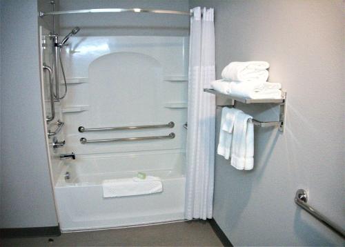 ein Badezimmer mit einer Dusche, einer Badewanne und Handtüchern in der Unterkunft Brookstone Inn & Suites in Fort Dodge