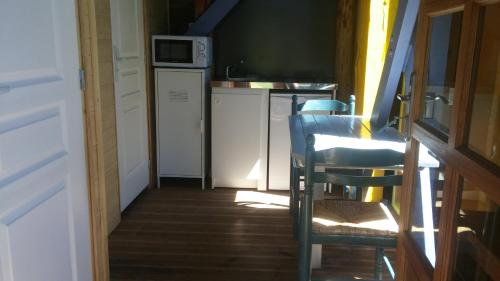 un couloir avec une cuisine équipée d'une table et de chaises dans l'établissement L'insolite du pic d'Ysson, à Vodable