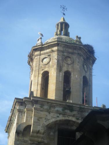 a tower with a clock on top of a building at Hotel El Cerco in Puente la Reina
