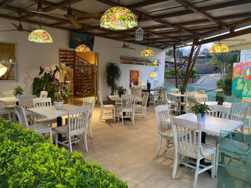 un restaurante con mesas blancas, sillas y luces en Hotel PZ Country Club & Conference Center, en San Isidro