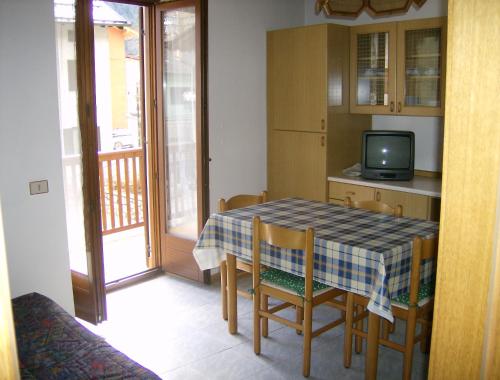 a kitchen with a table and chairs and a television at Casa Edelwaiss in Molveno