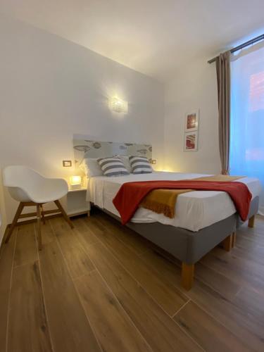 a bedroom with a bed and a chair and a window at Carruggio 151-2 in Sestri Levante