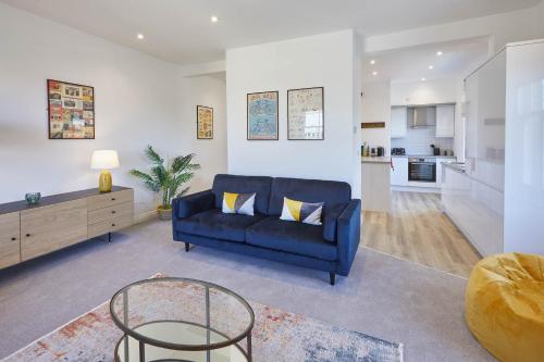 a living room with a blue couch and a table at Host & Stay - Cornerhouse Apartments in Saltburn-by-the-Sea
