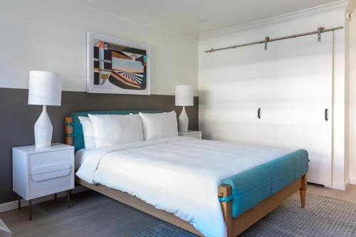 a bedroom with a large bed with a blue headboard at Signature Inn Oakland in Oakland