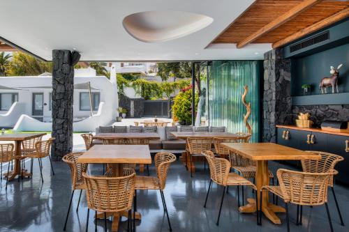 a restaurant with wooden tables and chairs at San Marino Suites by Calm Collection in Fira